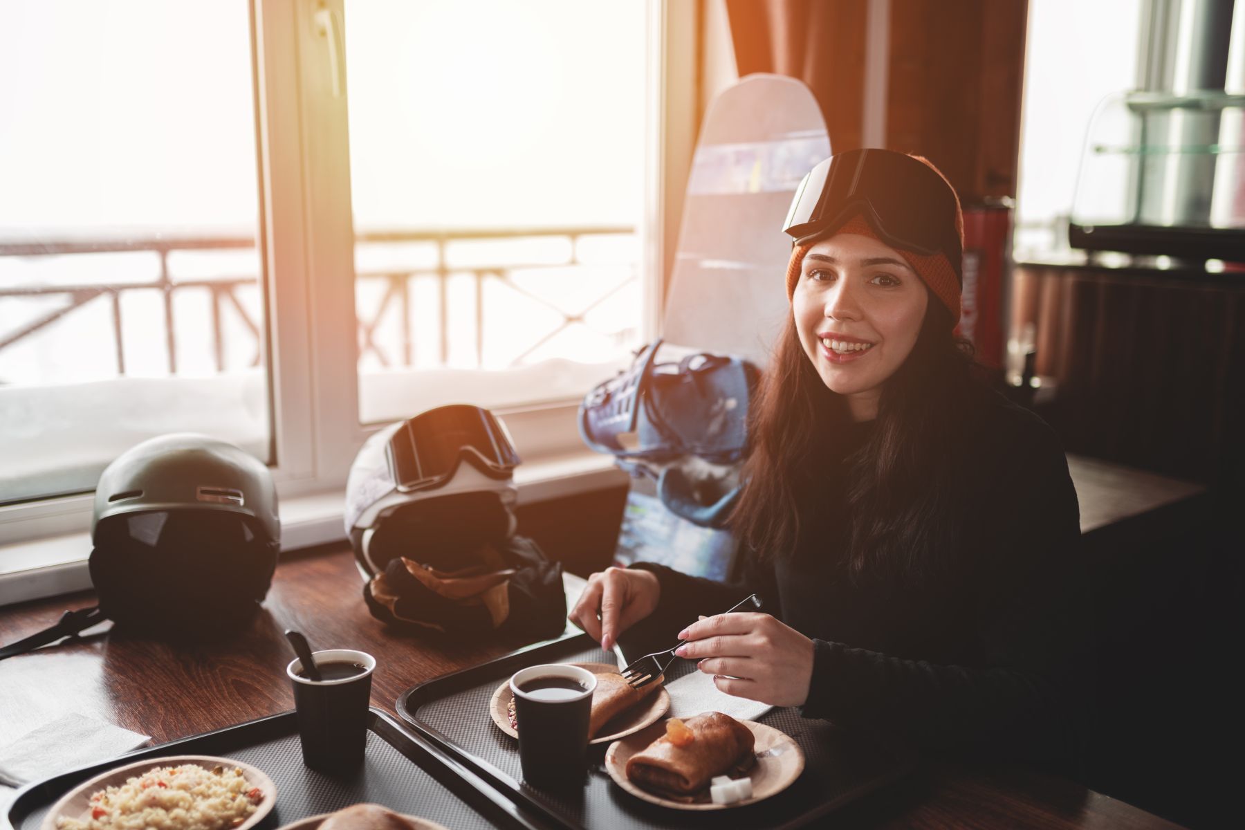 Woman with ski gear eating breakfast