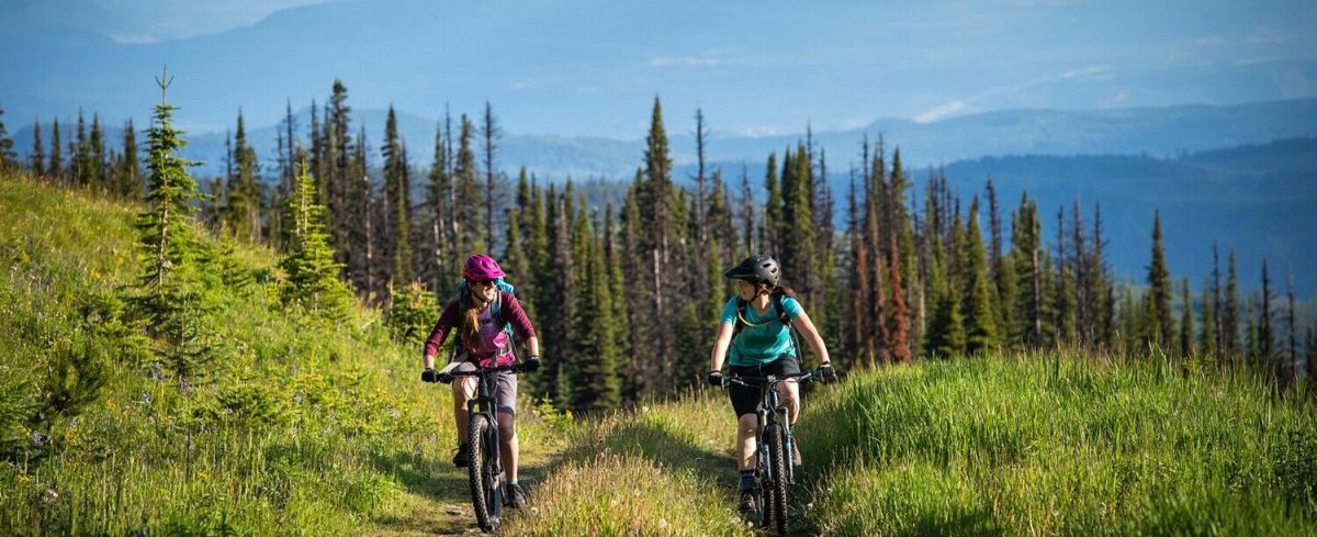 two women biking up a mountain
