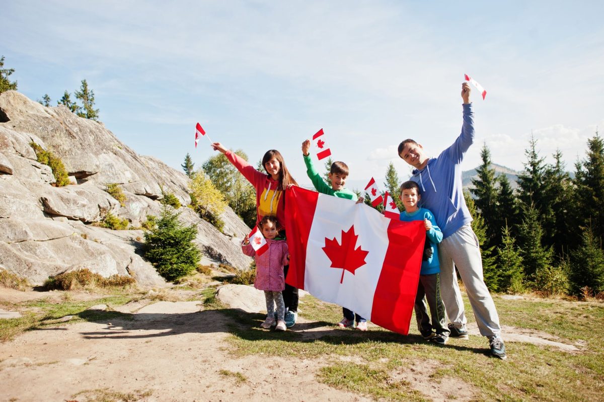 family holding Canadian flags in the mountains